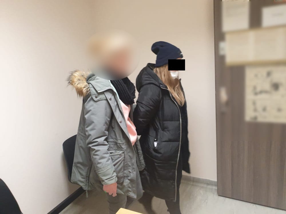 Dwie kobiety w zimowych płaszczach, zatrzymane i zwrócone twarzą do kamery.