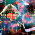 Zakapturzona postać zasłonięta kodem binarnym i rozmytymi okręgami, symbolizującymi zagrożenia cyberbezpieczeństwa.