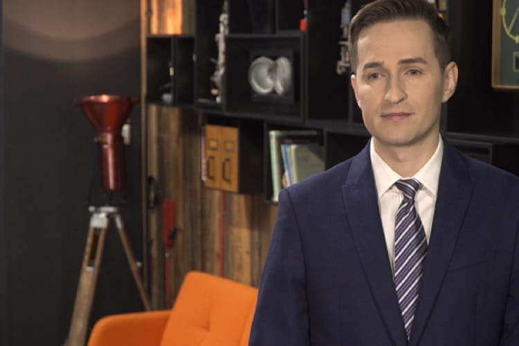 Biznesmen w garniturze i krawacie, stojący w biurze