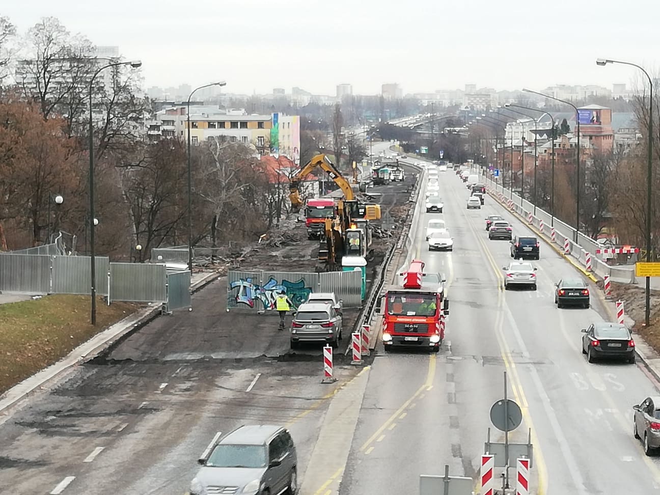 Budowa drogi na ulicy miejskiej z udziałem koparek i ruchu ulicznego.