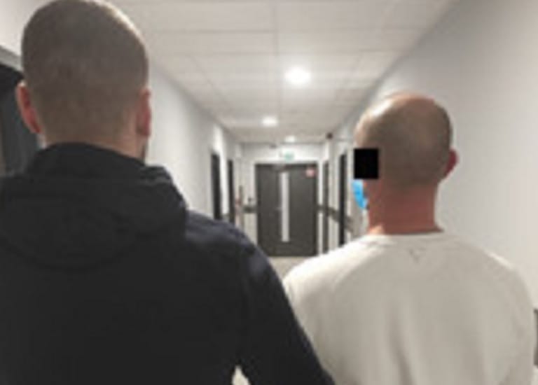 Dwóch mężczyzn idących korytarzem, widok z tyłu