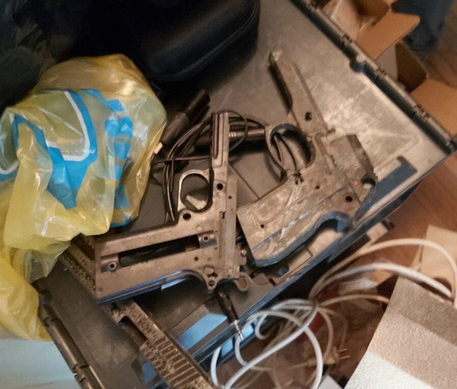 Rozłożone części broni w zagraconej skrzynce narzędziowej