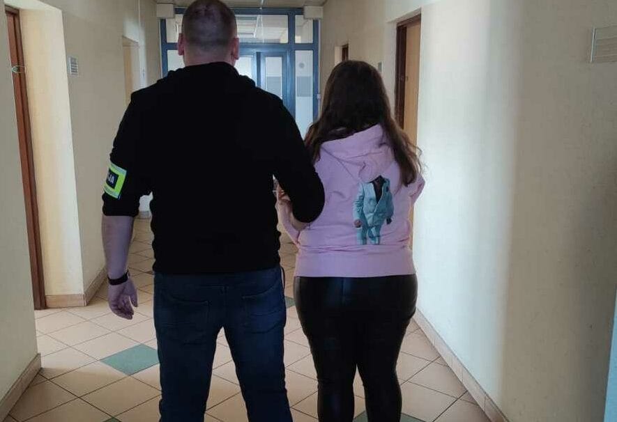 Ochroniarz eskortujący osobę korytarzem.