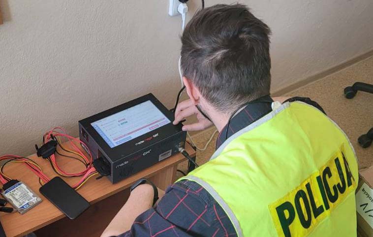 Policjant korzystający z oprogramowania do odzyskiwania danych kryminalistycznych. POLICJA.