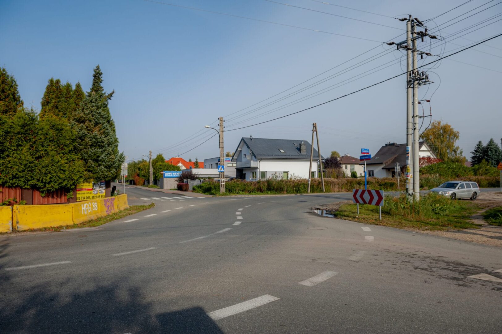 Skrzyżowanie ulic osiedlowych z domami i samochodami