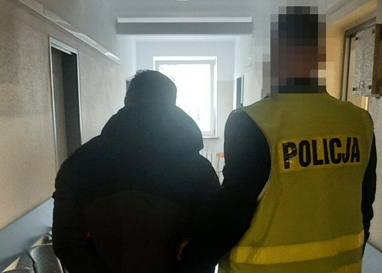 Policjant eskortujący podejrzanego korytarzem szpitalnym. POLICJA