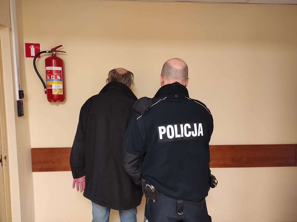 Policjant zatrzymujący mężczyznę na korytarzu. POLICJA