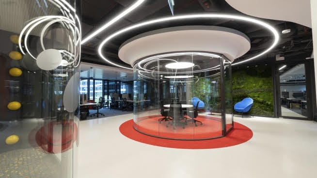 Nowoczesne wnętrze biurowe ze szklaną salą konferencyjną i zieloną ścianą