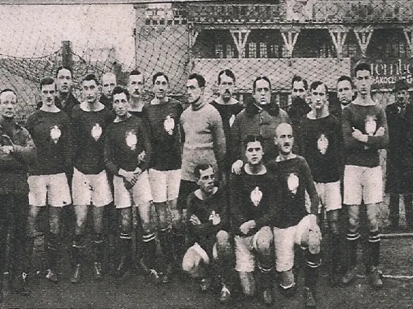 Portret drużyny piłkarskiej z początku XX w.; gracze w strojach pozują do grupowego zdjęcia.