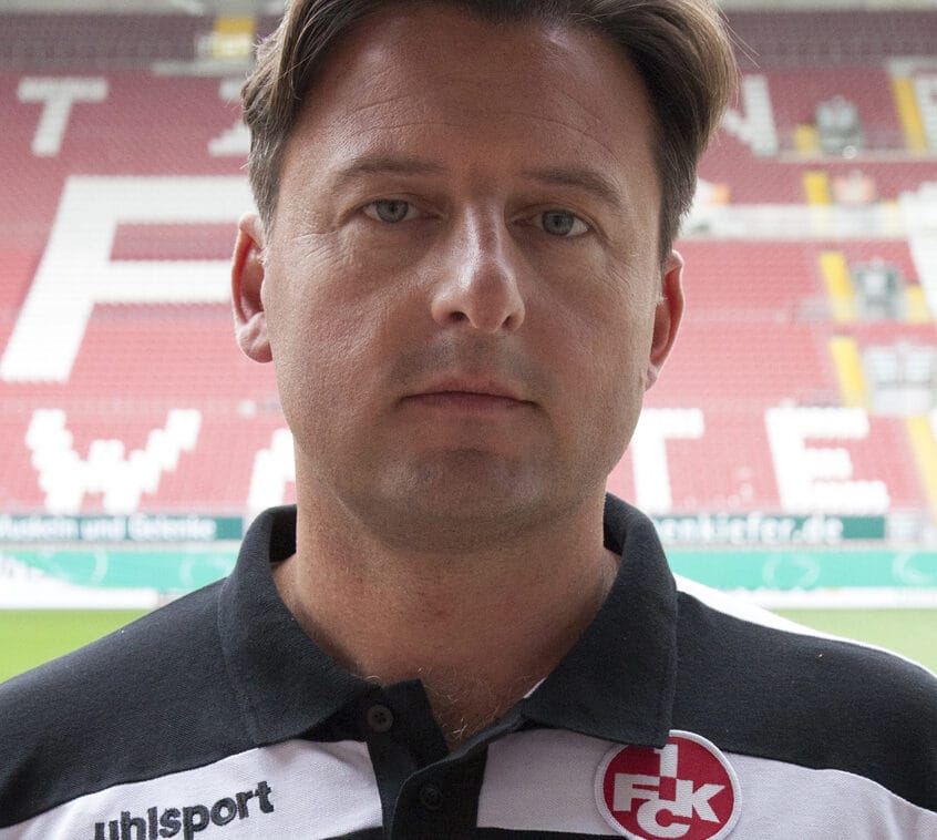 Zdjęcie dyrektora sportowego 1. FC Kaiserslautern w klubowej koszulce polo.