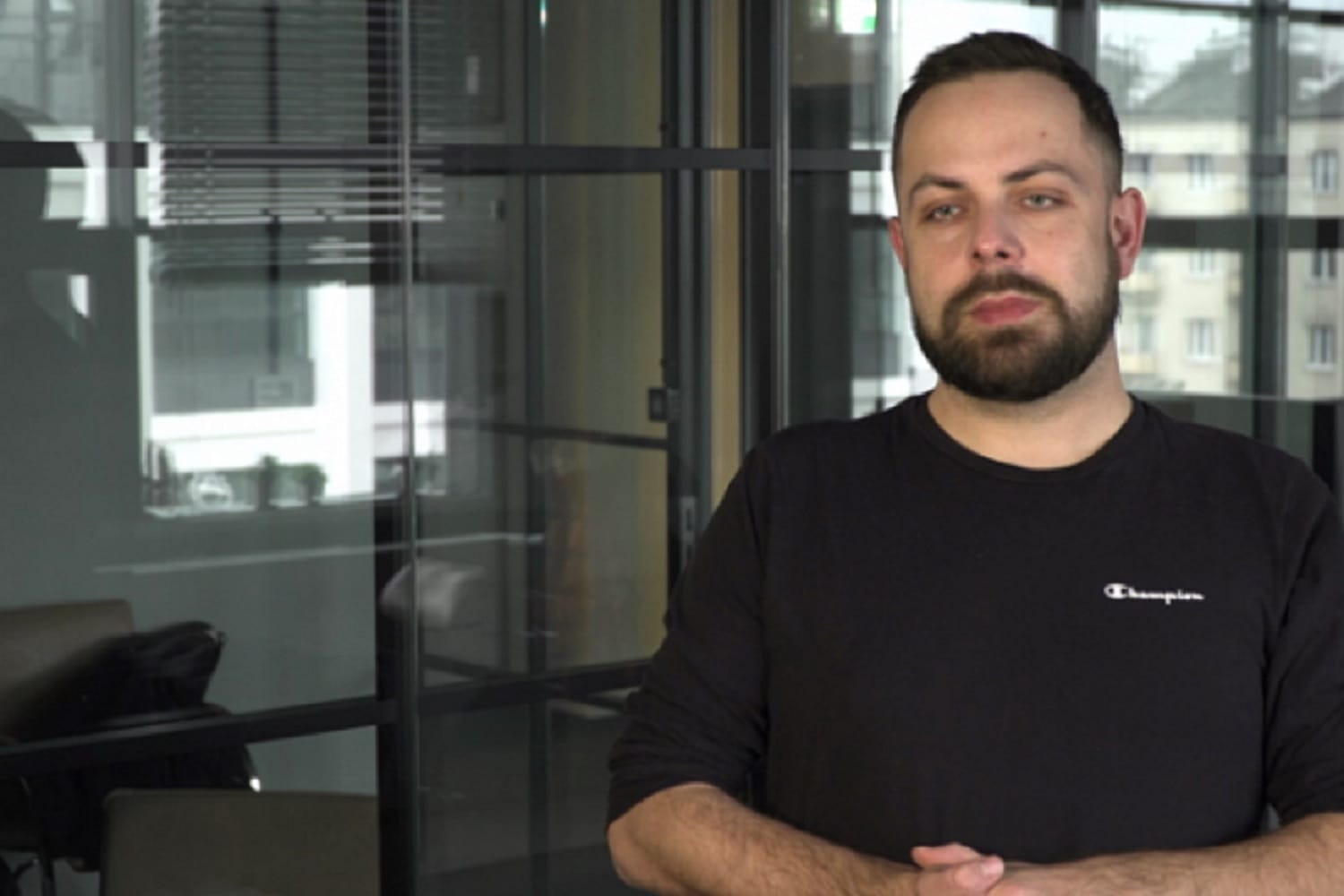 Mężczyzna z brodą w czarnej bluzie Champion