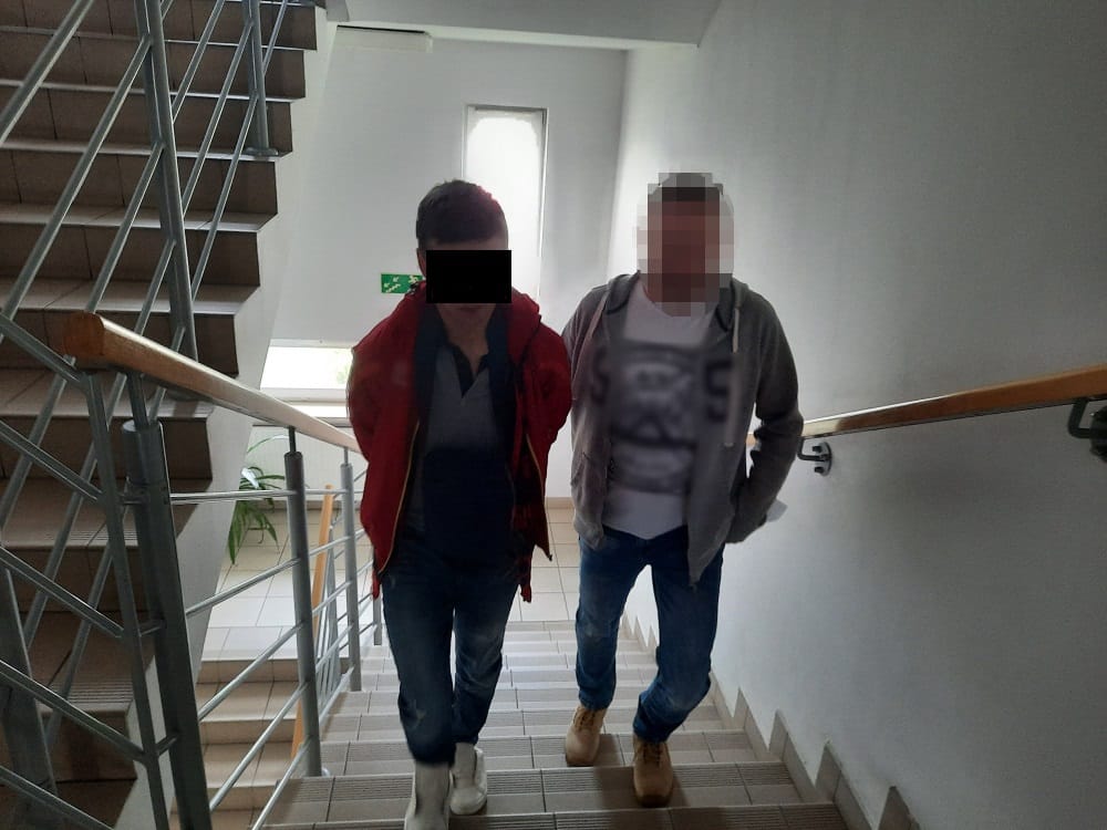 Dwóch podejrzanych w areszcie schodzi po schodach