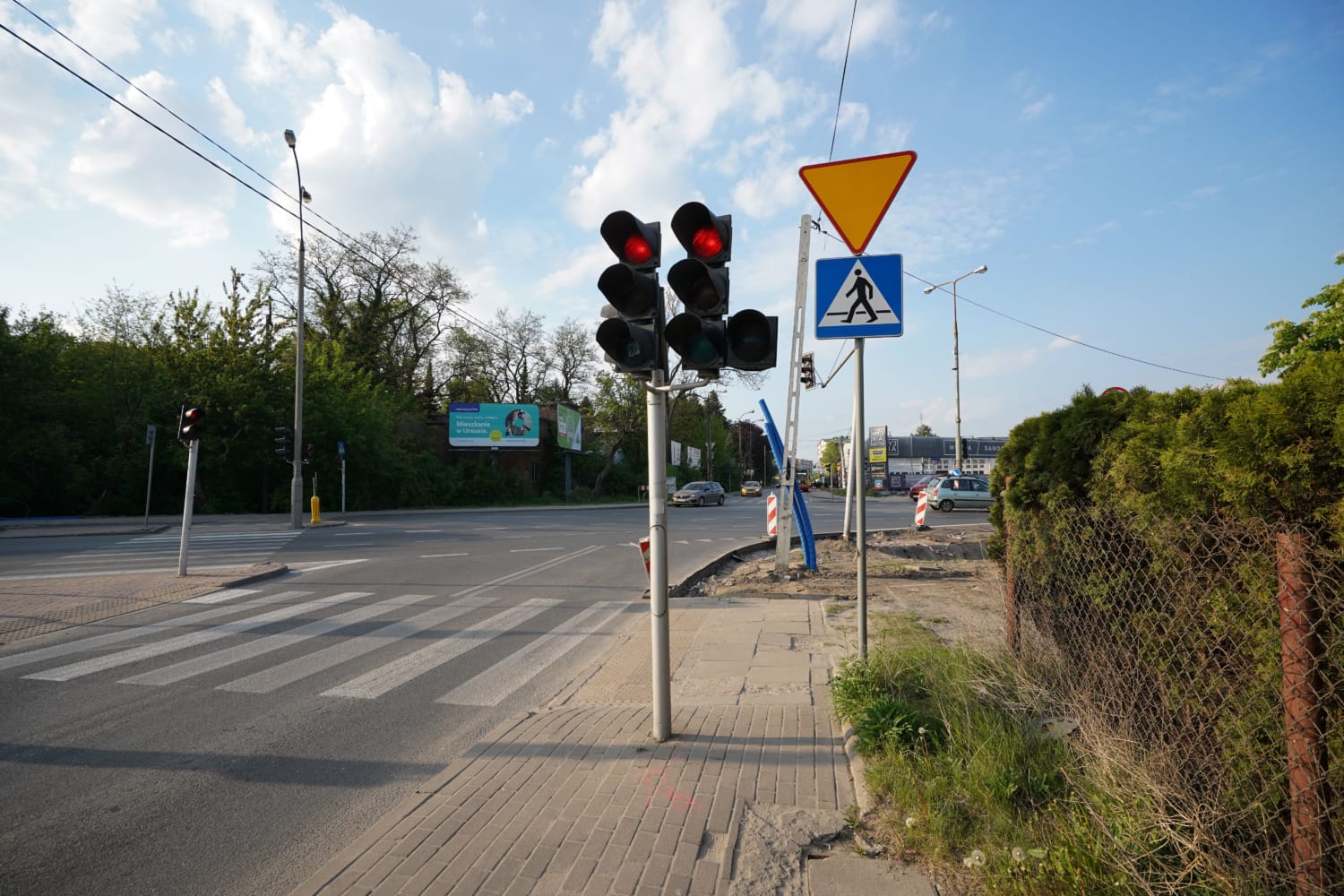 Czerwone światło na przejściu dla pieszych ze znakiem ustąp pierwszeństwa