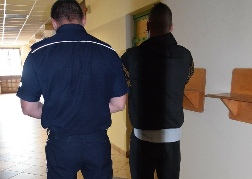 Strażnik więzienny eskortujący więźnia korytarzem