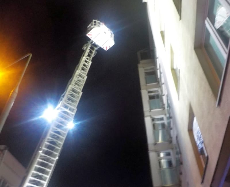 Drabina strażacka wysunięta do budynku w nocy