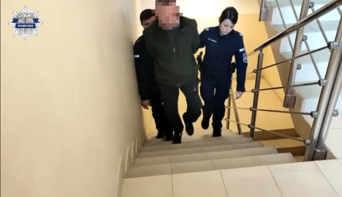 Policja eskortuje podejrzanego po schodach