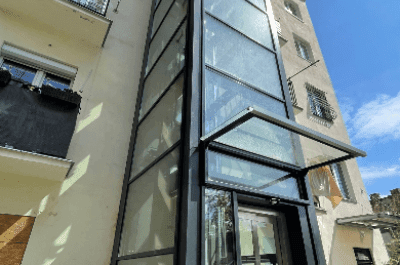 Nowoczesna szklana winda zainstalowana na zewnątrz budynku.