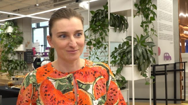 Uśmiechnięta kobieta w sukience z nadrukiem w arbuzy.