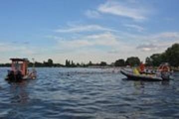 Ludzie biorący udział w wyścigu łodzi na spokojnym jeziorze