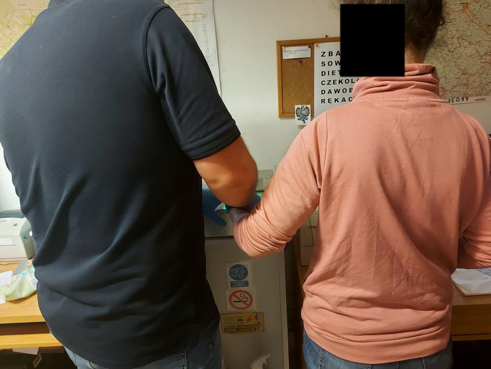 Dwie osoby w rękawiczkach obsługują wirówkę medyczną.