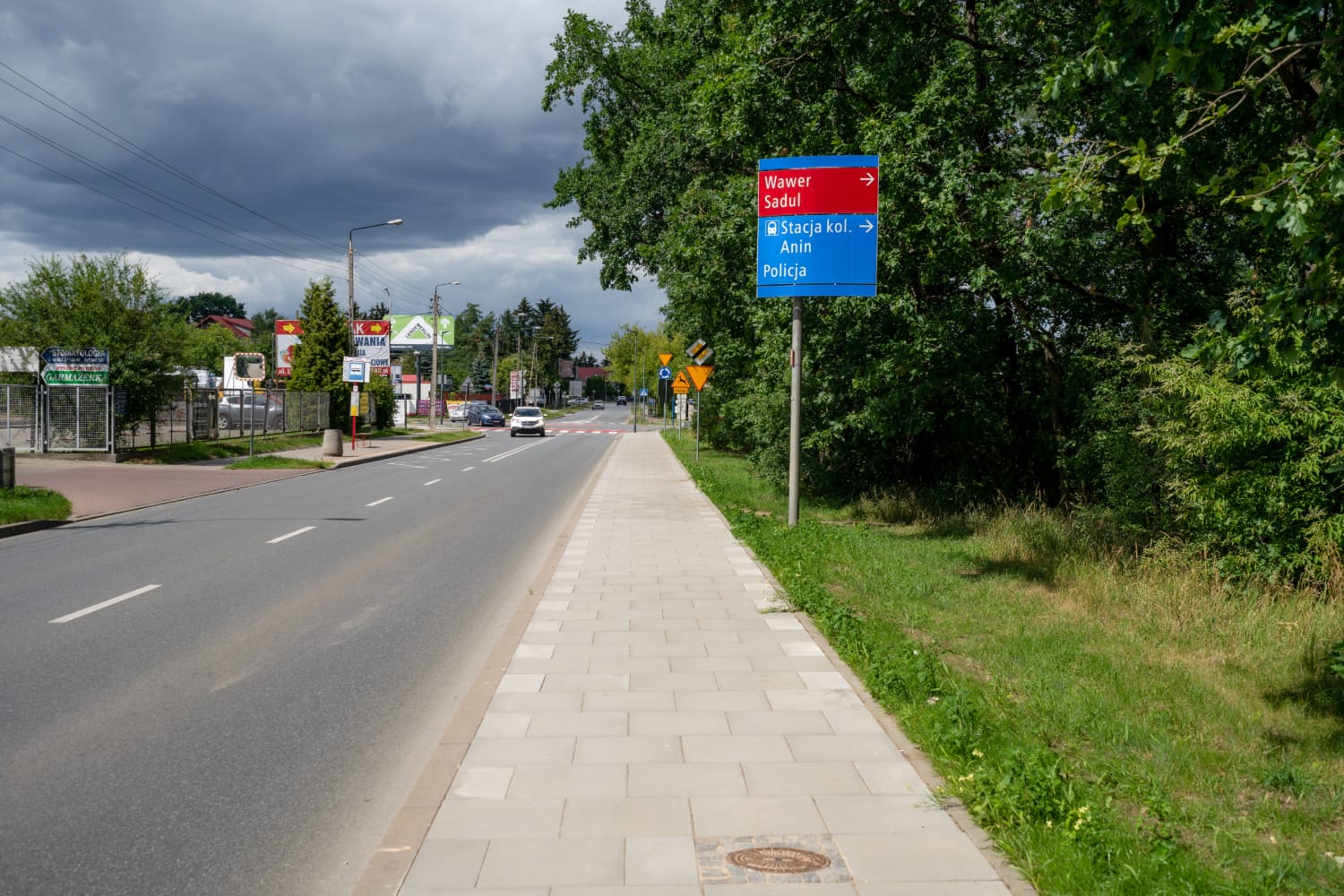Polska droga z drogowskazami do miejscowości Wawer, Sadul, Anin i lokalnego posterunku policji.