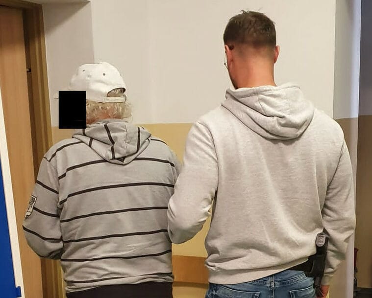 Policja eskortuje starszego mężczyznę, aresztowanie, śledztwo w sprawie przestępstwa
