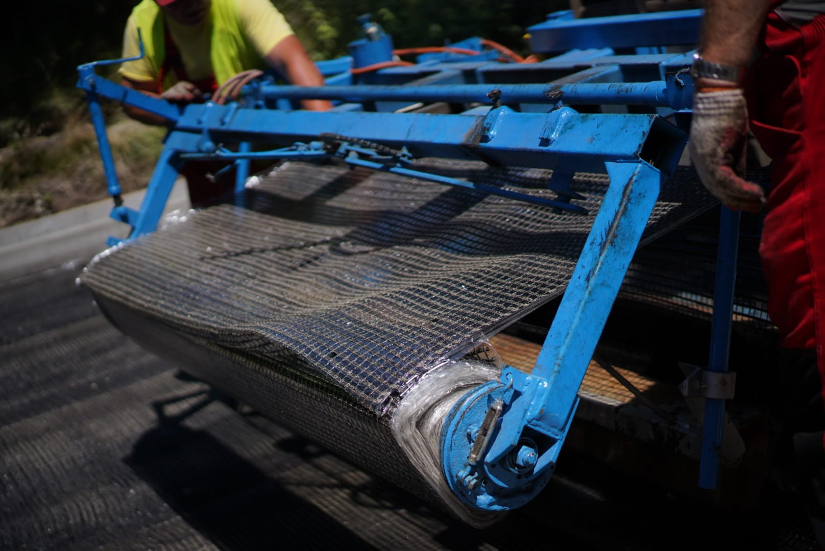 Robotnicy drogowi używają maszyny do układania asfaltu