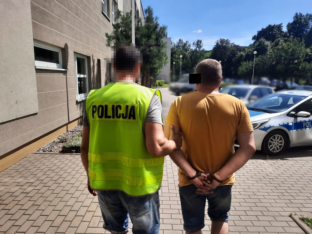 Policjant aresztujący podejrzanego z kajdankami. POLICJA