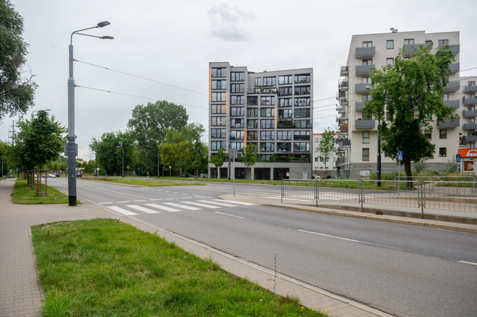 Nowoczesne budynki mieszkalne i przejście dla pieszych na ulicy miejskiej.