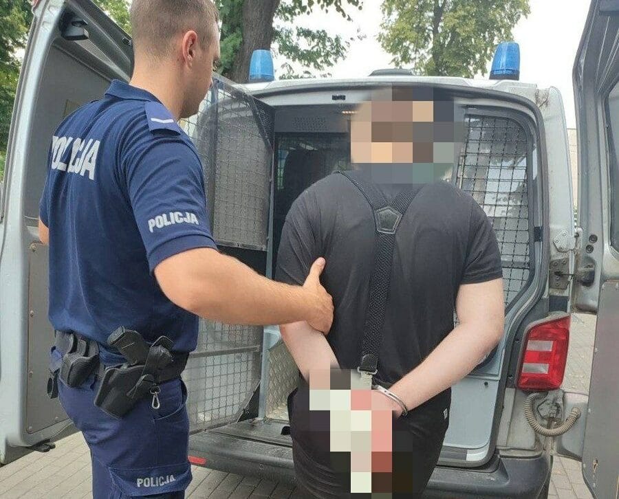 Policjant aresztujący podejrzanego, widoczne kajdanki.