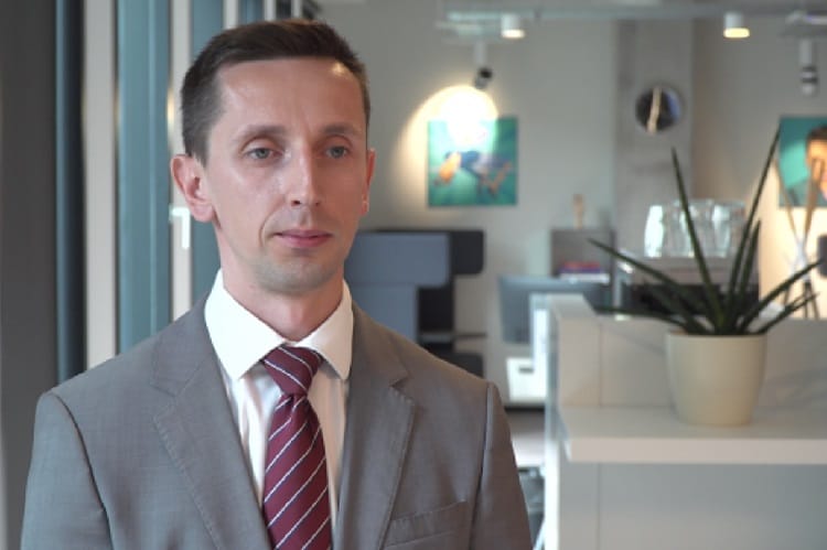 Portret mężczyzny w szarym garniturze i bordowym krawacie