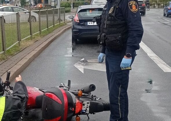 Miejsce wypadku motocyklowego, w którym policjant prowadzi dochodzenie. Motocyklista ranny.