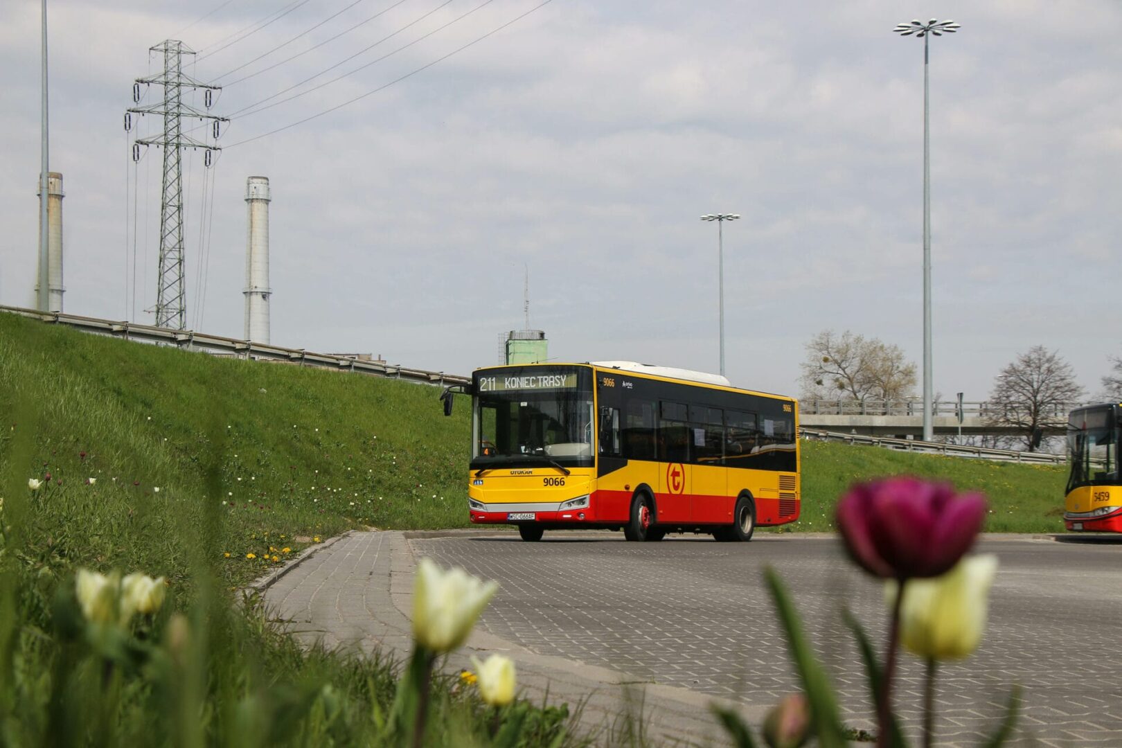 Żółty autobus miejski na końcu linii (211 KONIEC TRASY), numer 9066.