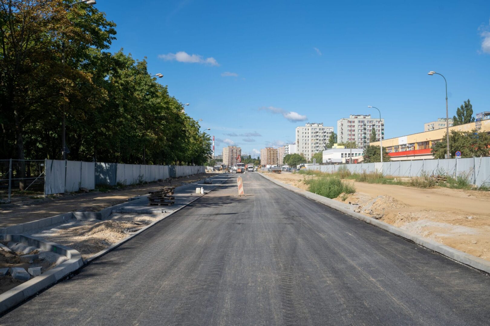 Nowo wyasfaltowana droga w budowie w pobliżu budynków mieszkalnych