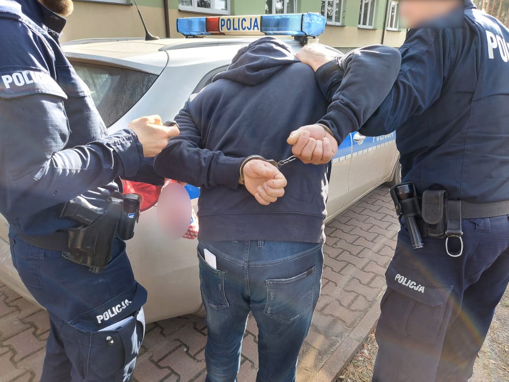 Policjanci zatrzymują podejrzanego w kajdankach. POLICJA
