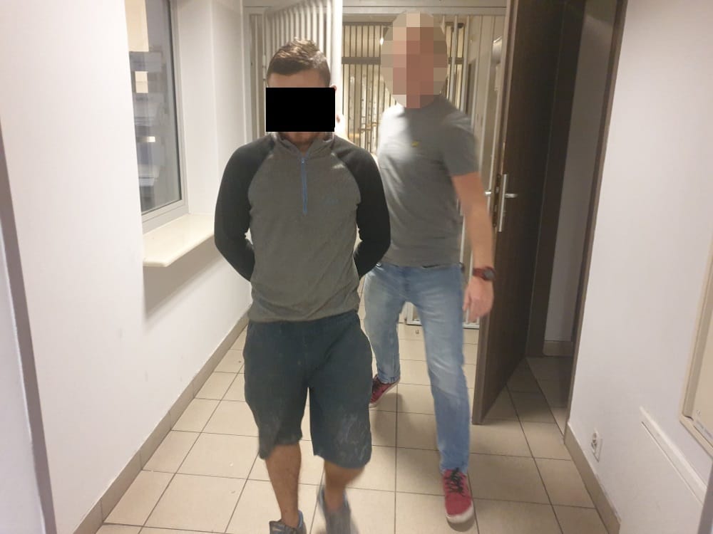Policja eskortuje podejrzanego korytarzem