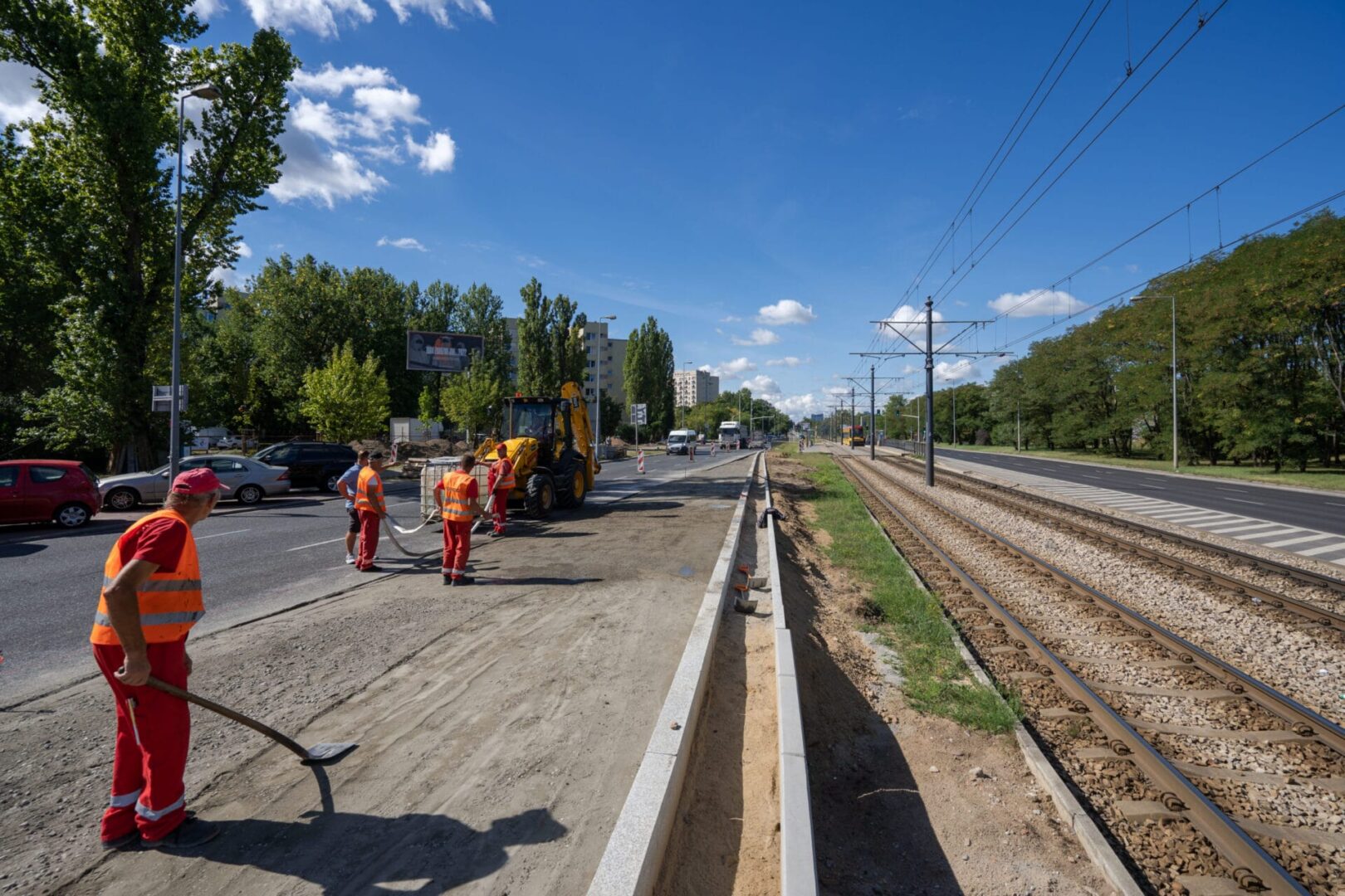 Ekipa drogowa pracująca na torach tramwajowych, używająca ciężkiego sprzętu