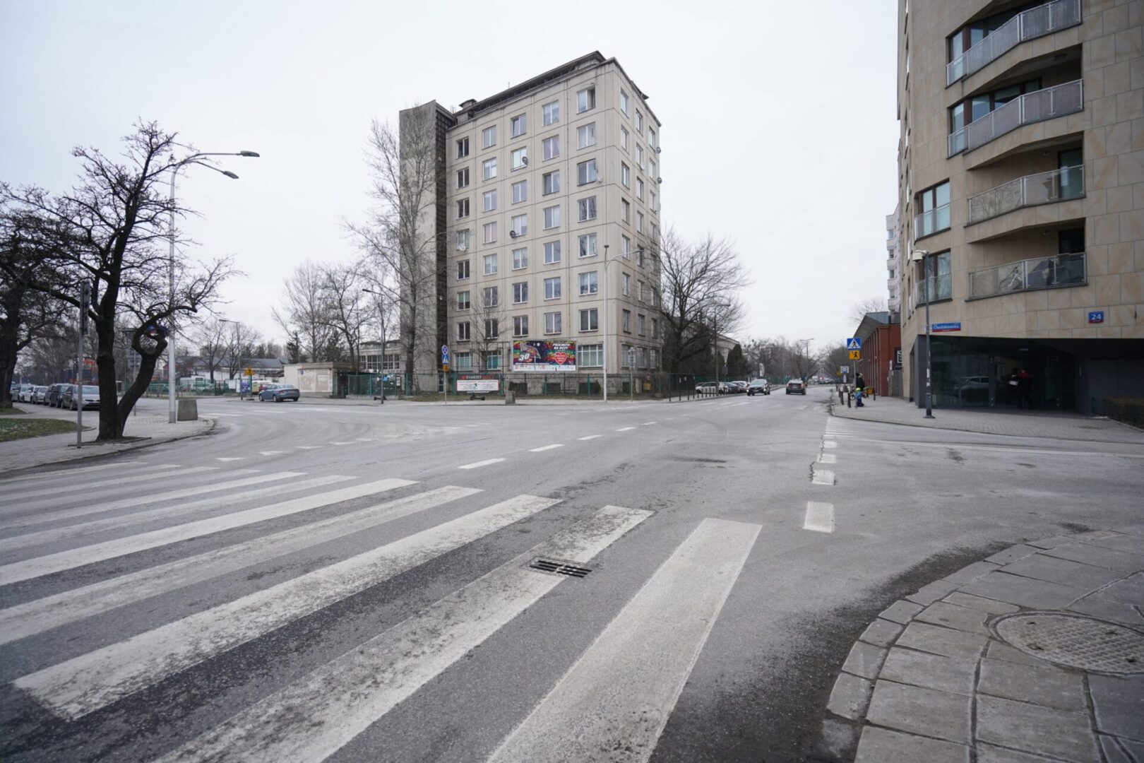 Opustoszałe skrzyżowanie miasta z wysokim budynkiem mieszkalnym i nowoczesną architekturą.