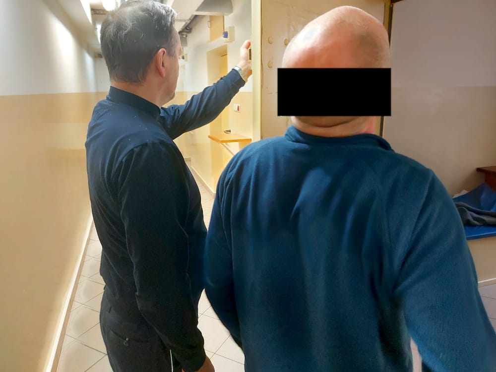 Strażnik więzienny pokazujący więźniowi celę