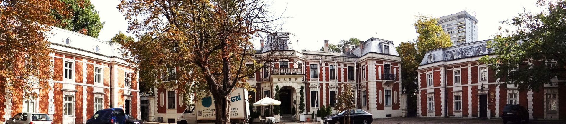 Eleganckie ceglane budynki przy ulicy obsadzonej drzewami.
