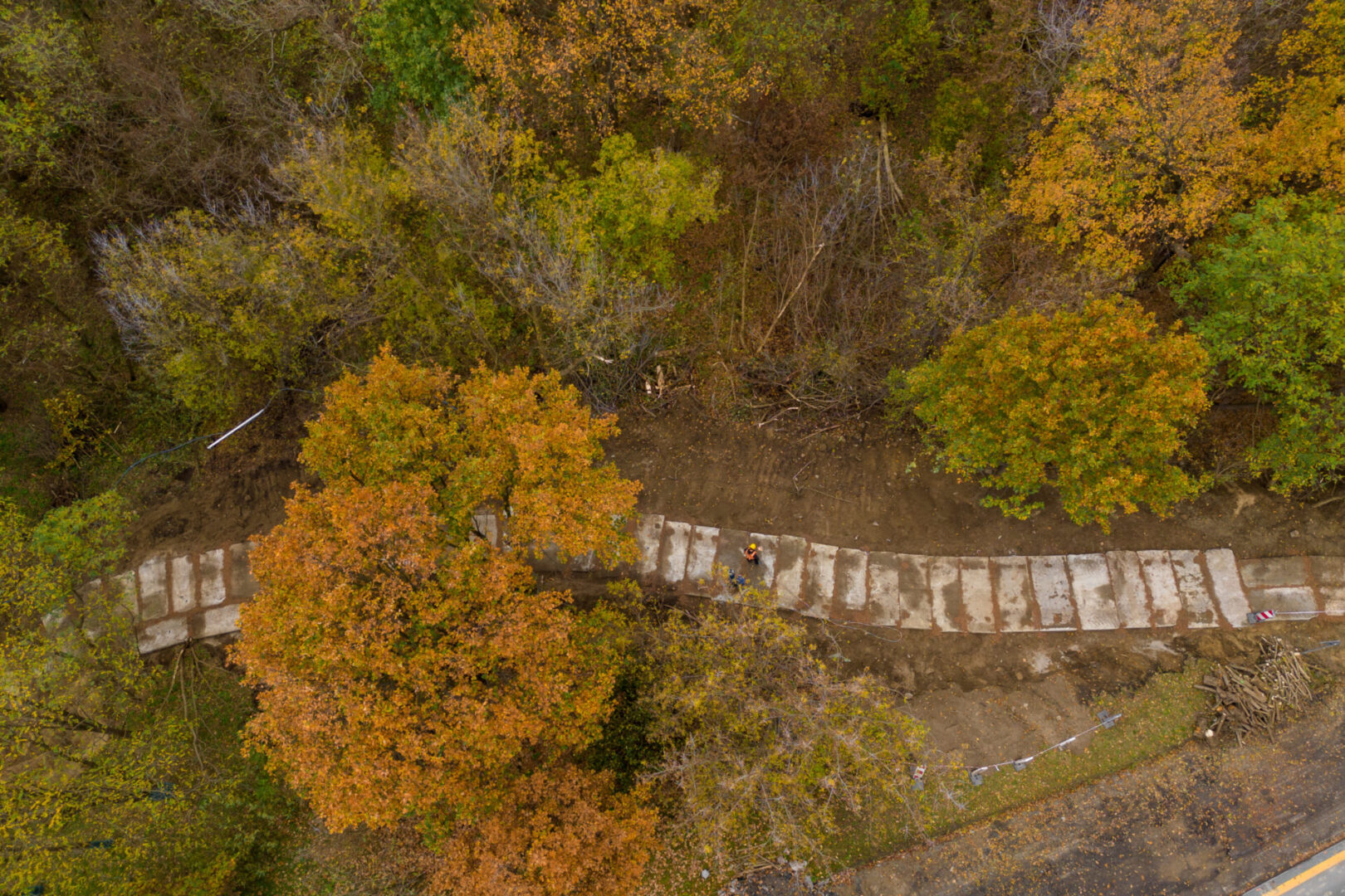 Widok z lotu ptaka na pracowników montujących prefabrykowane betonowe schody w parku jesienią.
