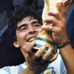 Diego Maradona świętuje, trzymając w górze trofeum Mistrzostw Świata FIFA po zwycięstwie Argentyny w 1986 r.