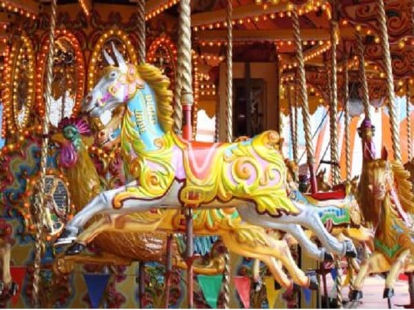 Ozdobne karuzele z końmi w żywych kolorach, klasyczna przejażdżka na wesołym miasteczku