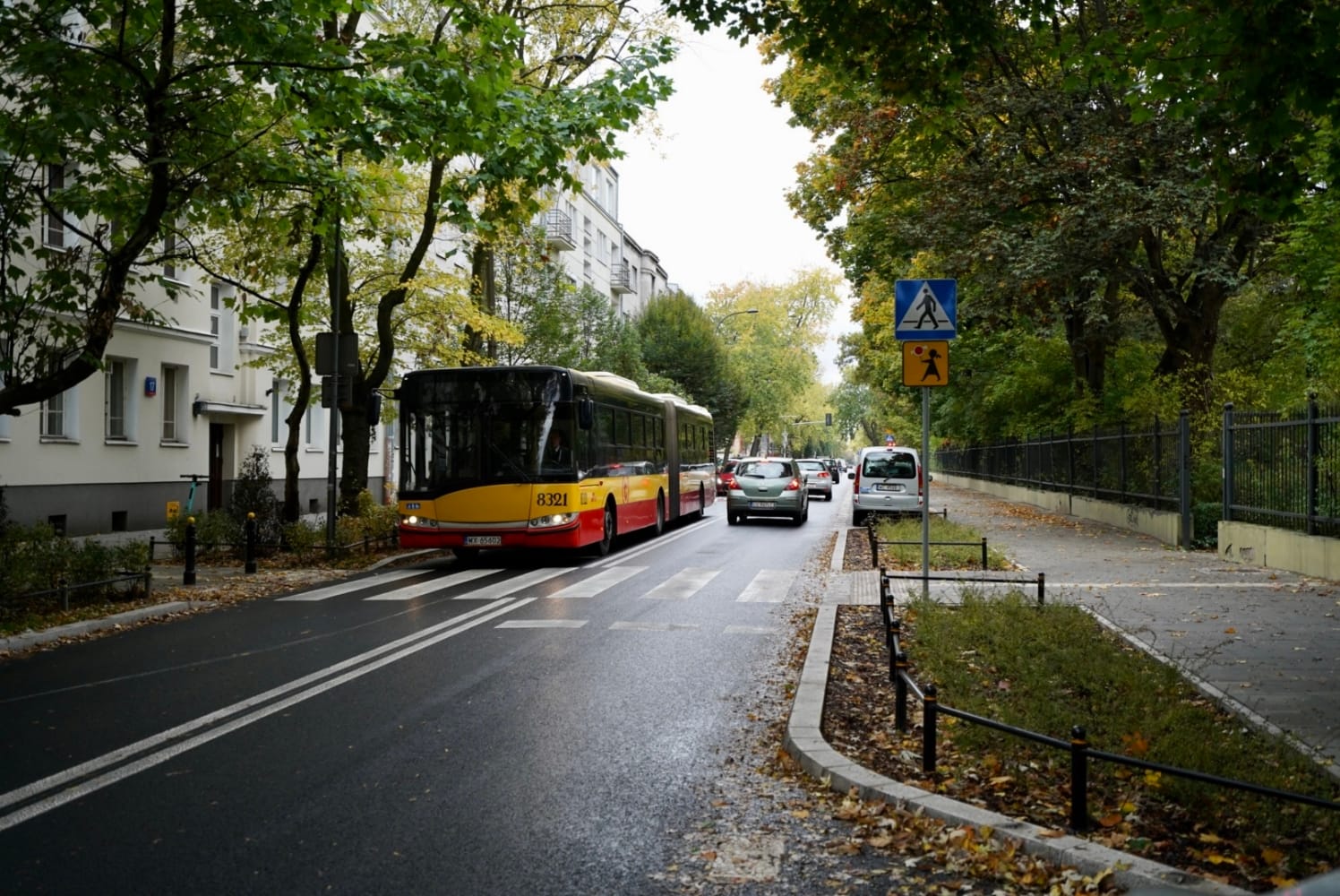 Autobus miejski na ulicy osiedlowej, jesienne liście