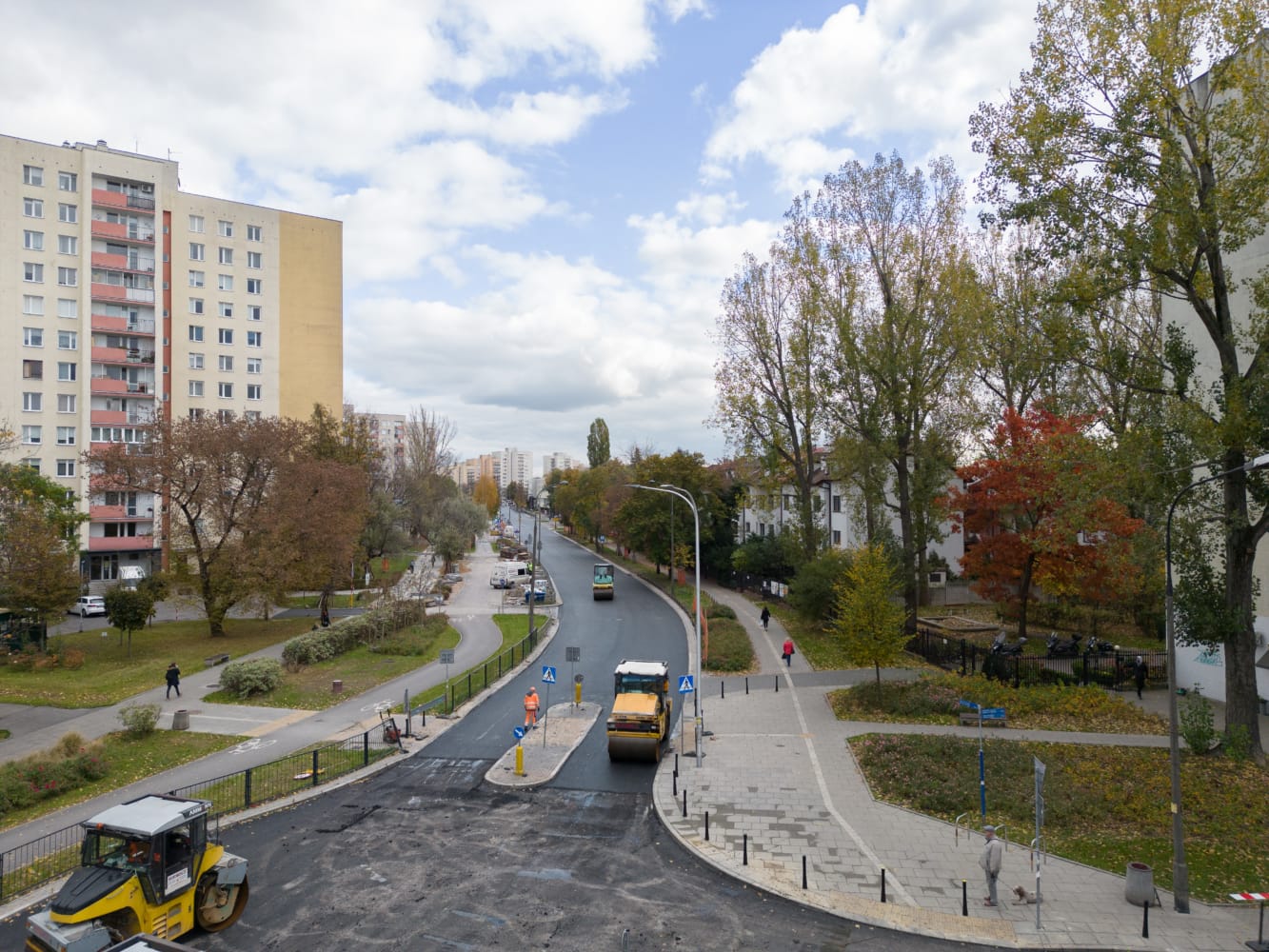 Budowa drogi w dzielnicy miasta. Robotnicy i walce drogowe.