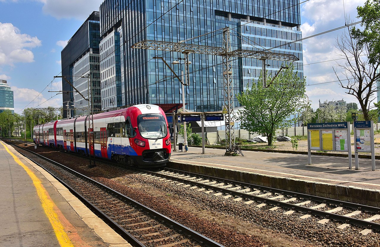 Czerwony i biały pociąg podmiejski przyjeżdżający na stację Warszawa Zachodnia WKD