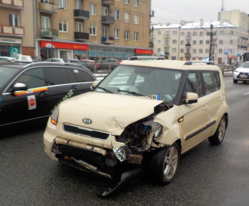 Beżowa Kia Soul z uszkodzonym przodem po wypadku samochodowym.