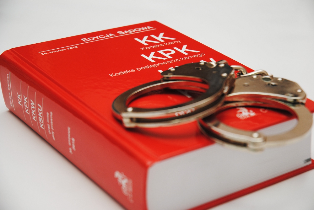 Kajdanki na księdze polskiego kodeksu karnego (Kodeks karny, Kodeks postępowania karnego)