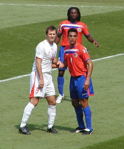 Piłkarze Kostaryki podczas meczu, prezentujący swoje czerwono-niebieskie stroje.