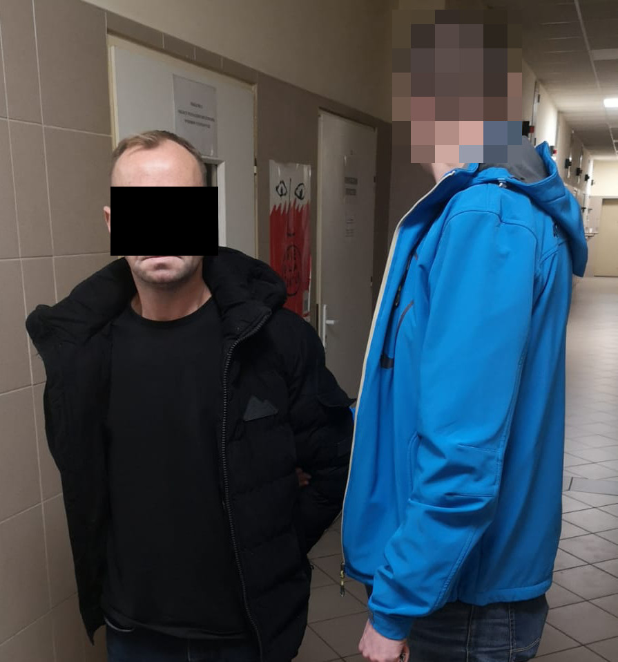 Aresztowanie przez policję: Mężczyzna w czarnej kurtce zatrzymany przez funkcjonariusza.